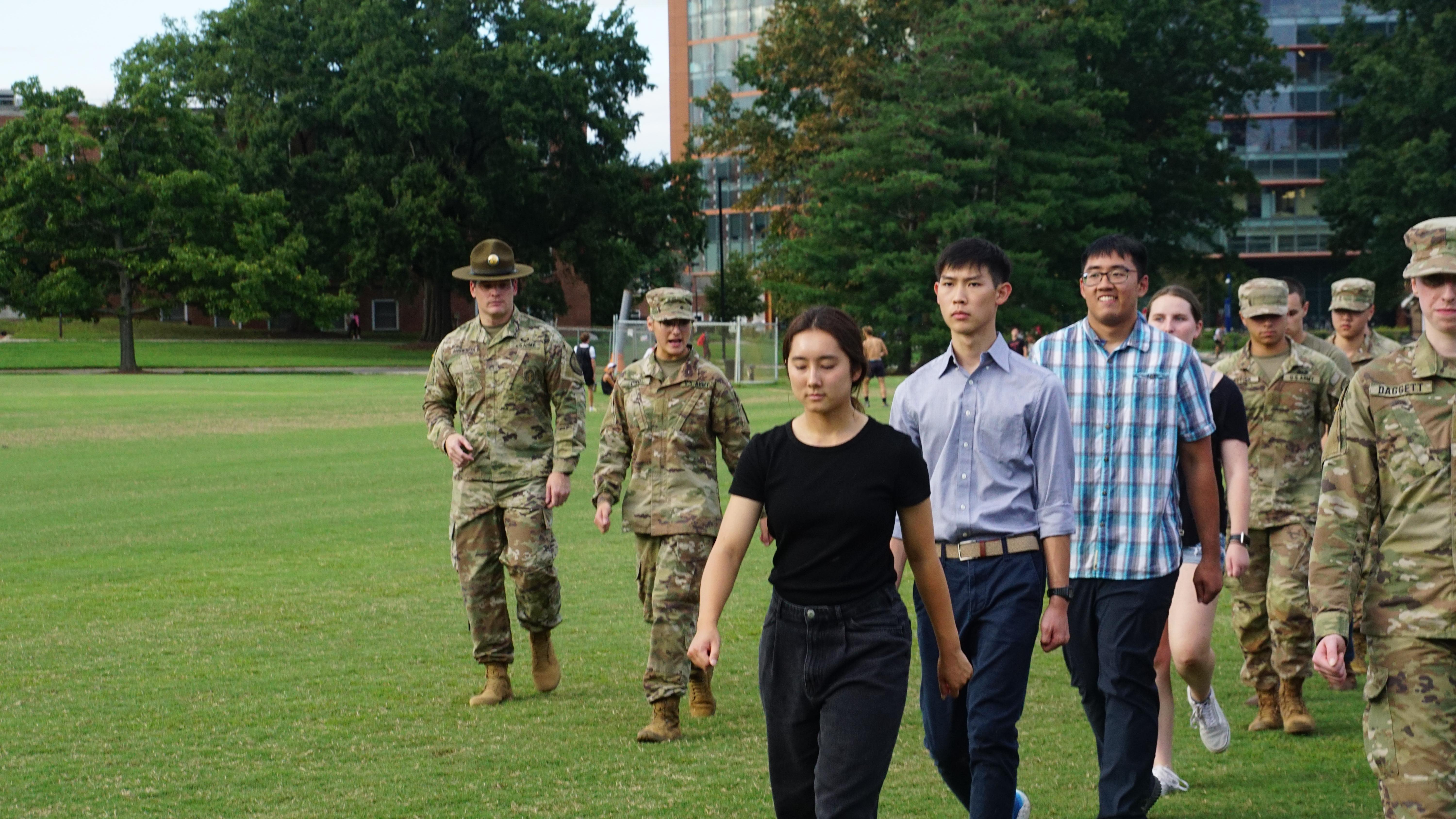 a CDT marches a formation with a drill sergeant advising